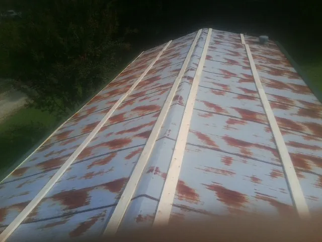Rusted metal roof panels with new wood purlins before replacement — Storm Damage Roof Repair in Brightwood by Roofing Brothers