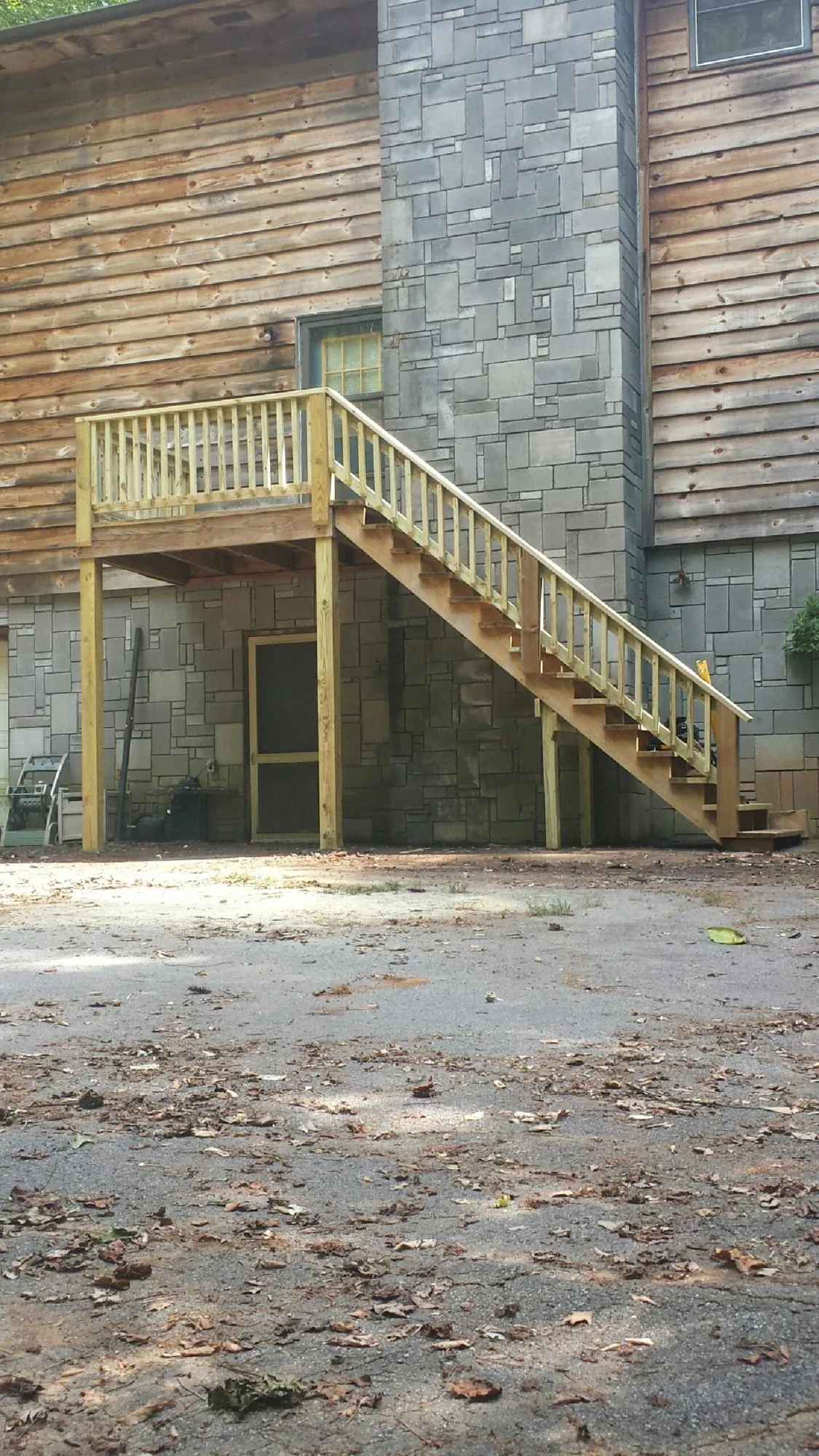 New pressure treated deck and stair landing on a log home in Brightwood